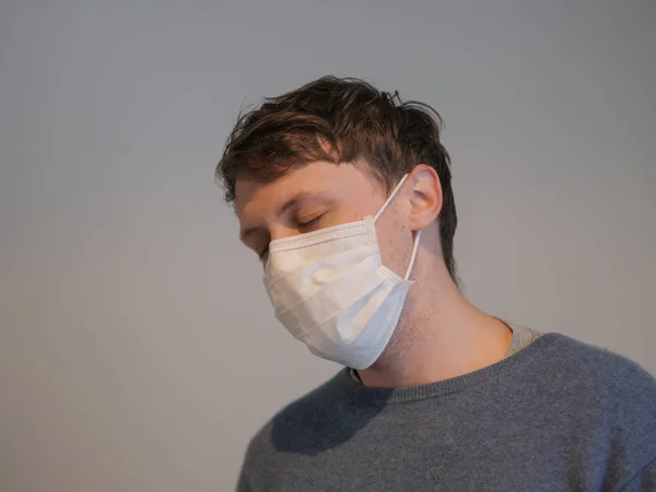 A handsome young man wearing a mask with the flu