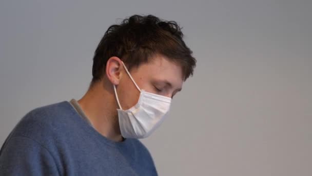 Een man met het griepvirus hoestend terwijl hij een chirurgisch masker draagt — Stockvideo