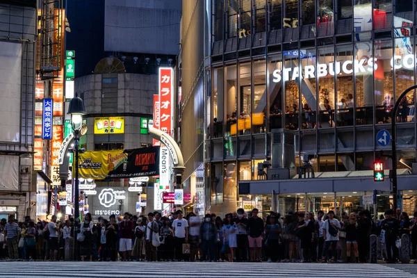 Shibuya, Japán - 16 6 19: Shibuya átkelés éjszaka forgalmas tömegekkel — Stock Fotó