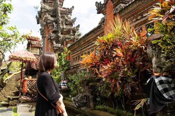 Genç ve güzel bir kadın Bali tapınağını geziyor.