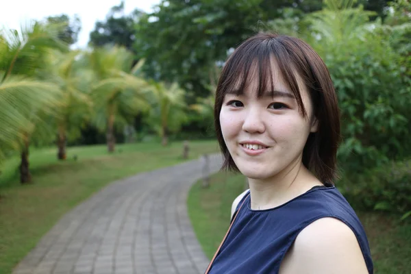 Ağaç yolundaki genç bir kadın