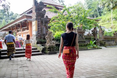 Bali, Endonezya - 24 6 2019: Bir kadın tatildeyken Bali tapınağına giriyor