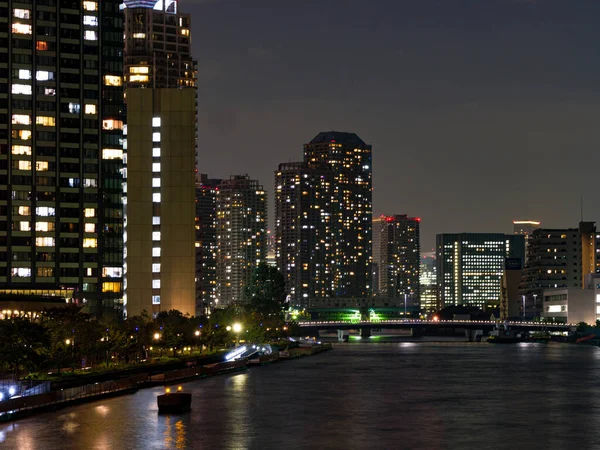 Tokyo 'daki yüksek binalar bir nehre yansıyor