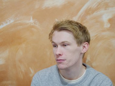 Turuncu arka planda izole edilmiş, mutlu bir yüzü olan bir adam.