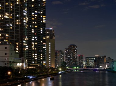 Tokyo 'daki yüksek binalar bir nehre yansıyor