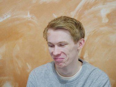 Turuncu arka planda izole edilmiş, mutlu bir yüzü olan bir adam.