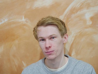 Turuncu arka planda izole edilmiş, mutlu bir yüzü olan bir adam.