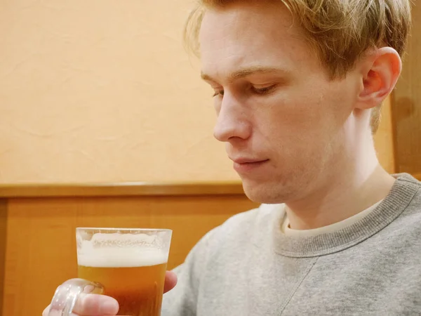 Гарний молодий чоловік насолоджується своїм пивом — стокове фото