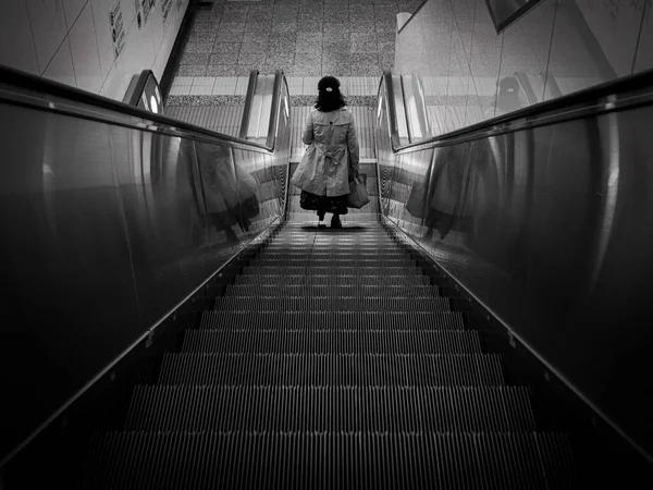 Eine Frau läuft in Eile die Rolltreppe hinunter. — Stockfoto