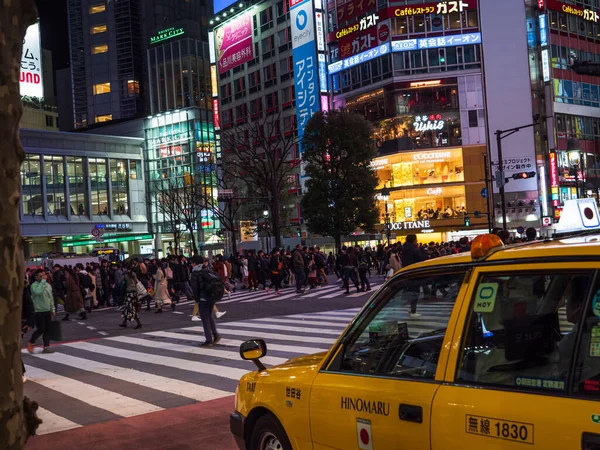 Shibuya, Japan - 7.2.20: Ein gelbes Taxi vor Shibuyas berühmter Kreuzung. — Stockfoto