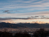 Město Kofu ve večerních hodinách obklopené horami