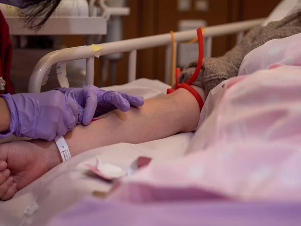 Медсестра вставляет канулу в руку пациента Лицензионные Стоковые Фото