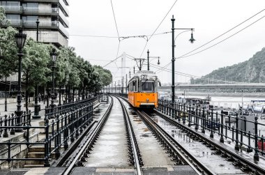 Belgrad Embankment yakınlarındaki Erzhebet Köprüsü 'nden Tuna Nehri üzerinden 2 numaralı turuncu tramvay geçiyor. Budapeşte, Macaristan