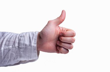 Beyaz gömlekli bir adamın elinde genellikle izole edilmiş beyaz arka planda baş parmak işareti olarak tanımlanan baş parmak işareti görülüyor.