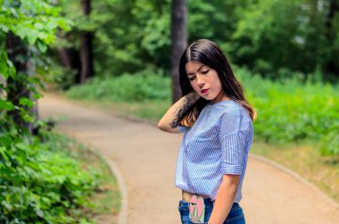 Güzel, şehvetli, esmer, dövmeli ve uzun siyah saçlı bir kadının portresi.