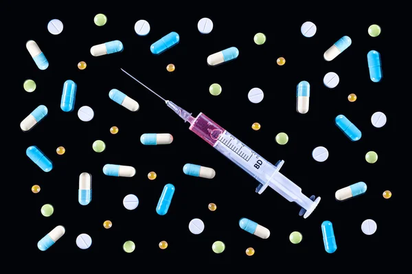医療用プラスチックのフラットレイ赤い液体 と黒の背景に様々なカラフルな丸薬 錠剤やカプセルで満たされた5ミリリットル注射器 トップ表示 — ストック写真