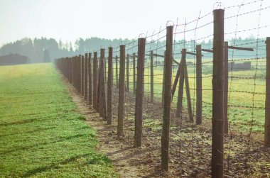 Alman konsantrasyonu ve imha kampı Majdanek 'te dikenli teller arasındaki çim ve yol. Lublin, Polonya