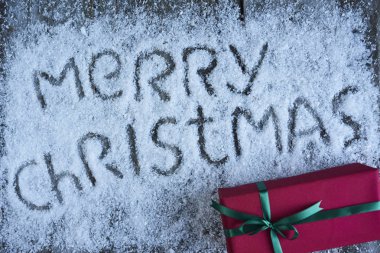 Hediye kutusu ile ahşap b üzerinde yazı neşeli Noel elle çizilmiş