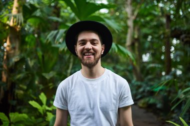 Botanik Bahçesi siyah şapka ayakta giyen Closeup sakallı portre yakışıklı şık adam arka plan bulanık