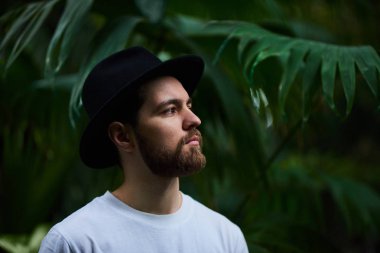 Botanik Bahçesi siyah şapka ayakta giyen Closeup sakallı portre yakışıklı şık adam arka plan bulanık