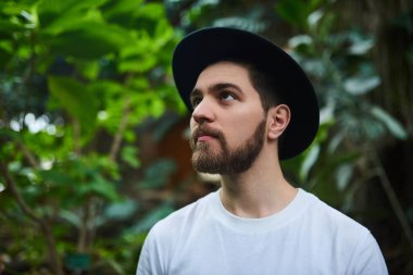 Botanik Bahçesi siyah şapka ayakta giyen Closeup sakallı portre yakışıklı şık adam arka plan bulanık