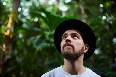 Botanik Bahçesi siyah şapka ayakta giyen Closeup sakallı portre yakışıklı şık adam arka plan bulanık