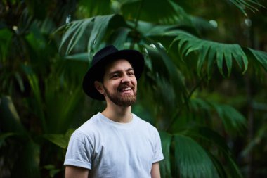 Botanik Bahçesi siyah şapka ayakta giyen Closeup sakallı portre yakışıklı şık adam arka plan bulanık