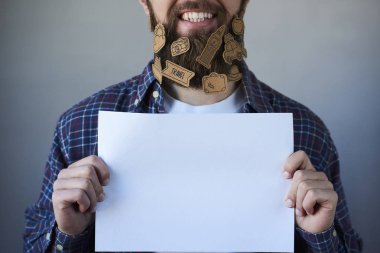 Sakal gösteren gri arka plan boş beyaz kart çıkartmaları ile yakışıklı adam