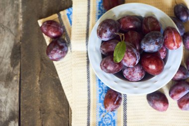 Plaka ahşap arka plan üzerinde taze Erik