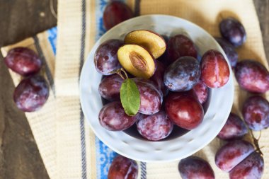 Plaka ahşap arka plan üzerinde taze Erik