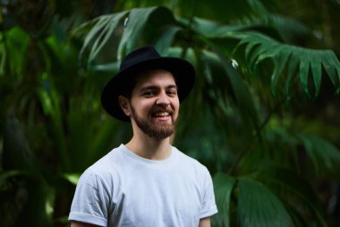 Botanik Bahçesi siyah şapka ayakta giyen Closeup sakallı portre yakışıklı şık adam arka plan bulanık