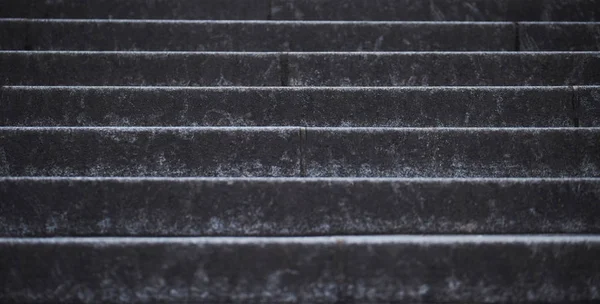 Closeup of old stairs. Dark grey textured concrete stairs background