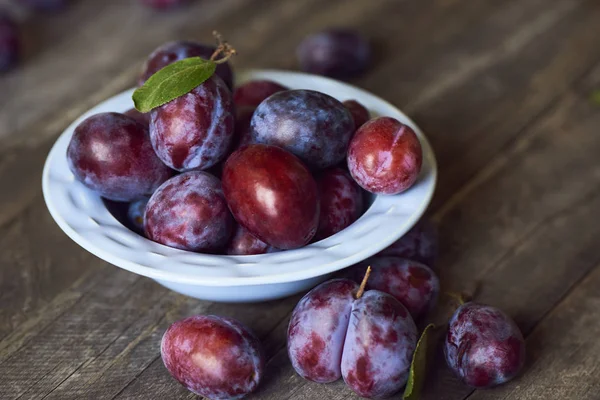 Prunes Fraîches Dans Une Assiette Sur Fond Bois — Photo