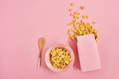 Kutu tahıllar, pembe plaka ve kaşık pembe arka plan, üstten görünüm
