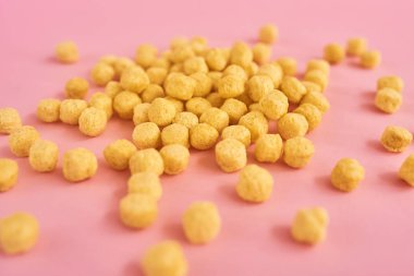 Mısır gevreği veya tahıl pembe bir arka plan üzerinde