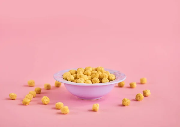 Closeup of blue plate of cereals on pink background