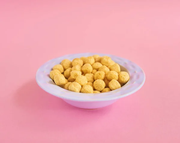 Closeup of blue plate of cereals on pink background