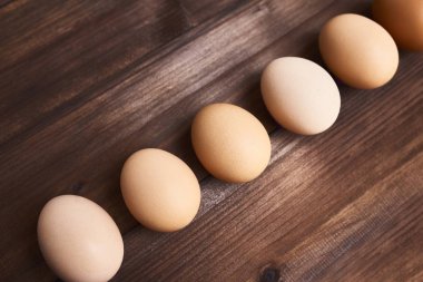 Ahşap arka plan satırındaki döşeme taze tavuk yumurta.