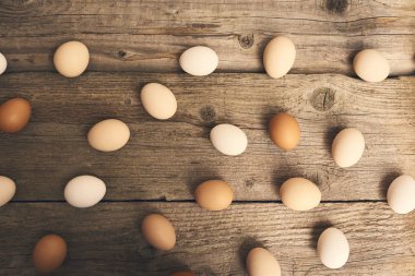 Tavuk taze çiğ yumurta parlak kahverengi ahşap masa arka plan üzerinde görünümünü yakın çekim.