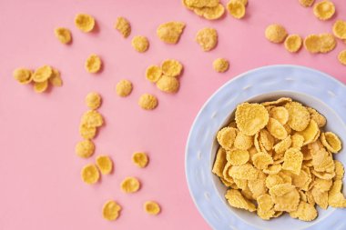 Mısır gevreği mavi tabak üstten görünüm pembe bir arka plan üzerinde