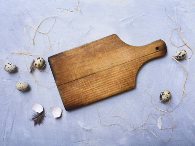 Arka plan ile taze bıldırcın yumurtası, rustik yönetim kurulu, saman ve tüyler mavi Beton taş arka plan üzerinde kesme.