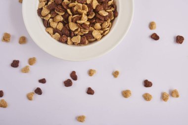 Beyaz arka plan üzerinde izole kahverengi ve bej Mısır gevreği ile beyaz plaka Üstten Görünüm