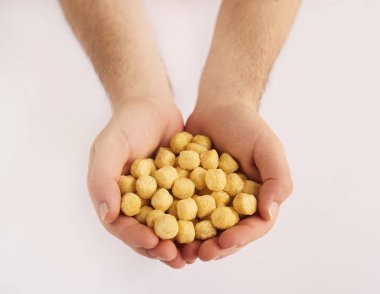 Beyaz arka plan üzerinde izole Mısır gevreği holding erkek eller