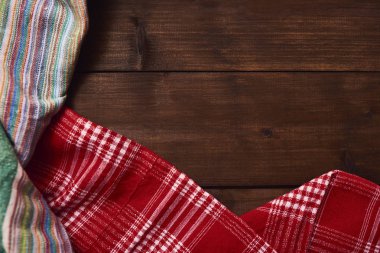 Farklı renkli mutfak havlu ile kahverengi rustik ahşap masa arka plan.