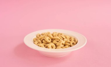 Bej Mısır yüzük pembe bir arka plan üzerinde beyaz tabak