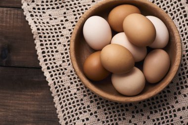 Rustik ahşap zemin üzerine peçete ahşap kase taze çiğ tavuk yumurta Üstten Görünüm.