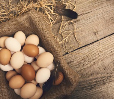 Tavuk taze çiğ yumurta çul kutusu ve saman parlak kahverengi ahşap masa arka plan üzerinde Üstten Görünüm.