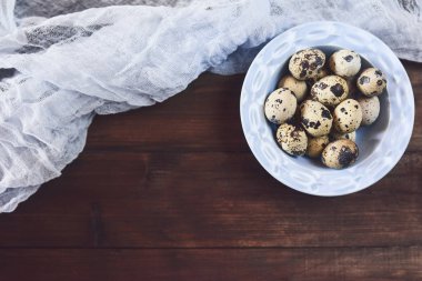 Bıldırcın taze yumurta ile tülbent rustik ahşap zemin üzerine mavi kapta.