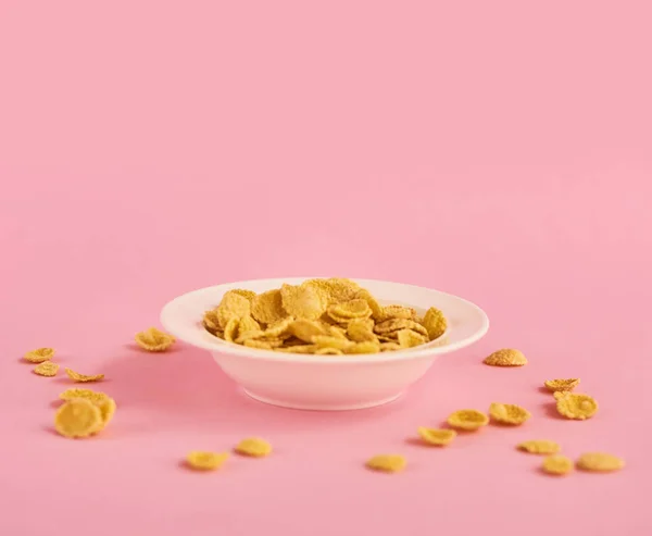 Vit Tallrik Med Beige Cornflakes Rosa Bakgrund — Stockfoto