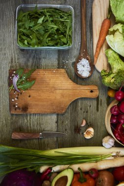 Ahşap arka plan üzerinde kesme tahtası ile taze çiğ sebze